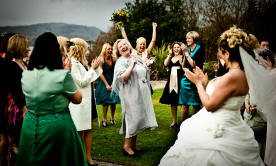 Bride throwing bouquet in wedding photograph
